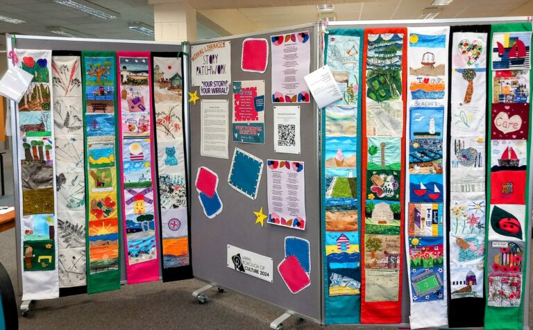 In a welcoming room with fluorescent lighting, three display boards feature quilt panels adorned with colourful designs and artworks, creating a warm and artistic atmosphere within the residential care home.